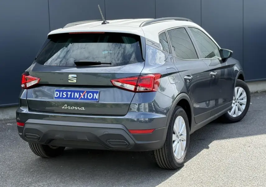 Vue 3/4 arrière droite d’un SEAT Arona gris magnétique avec toit blanc et vitres arrière surteintées.