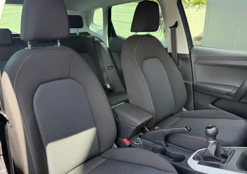 Vue intérieure des sièges avant noirs et de la console centrale avec levier de vitesse manuelle du SEAT Arona TSI 115 Style 2025.
