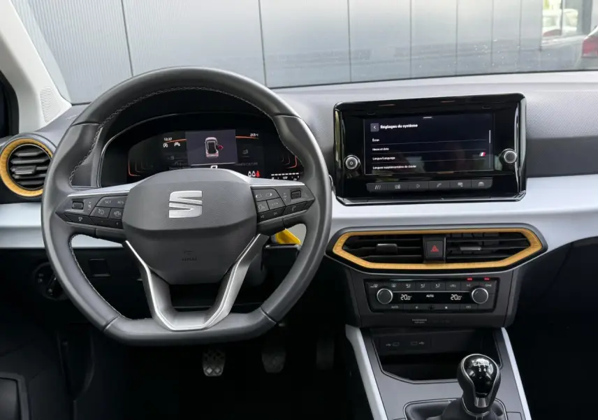 Vue intérieure frontale du tableau de bord du SEAT Arona TSI 115 Style 2025 avec volant multifonction et écran tactile.