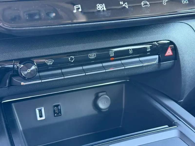 Détail de la console centrale du Citroën C5 Aircross 2025, montrant les commandes noires tactiles et prises USB avec prise 12V.