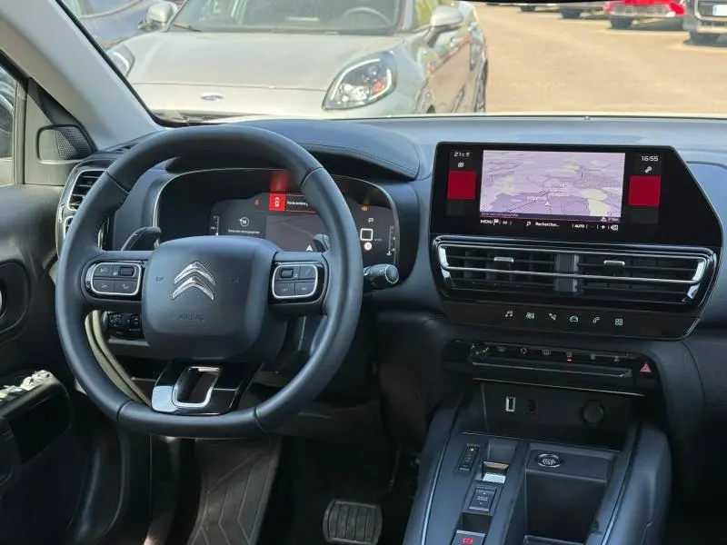 Vue intérieure du tableau de bord et volant du Citroën C5 Aircross 2025 hybride, avec écran tactile et commandes intégrées.