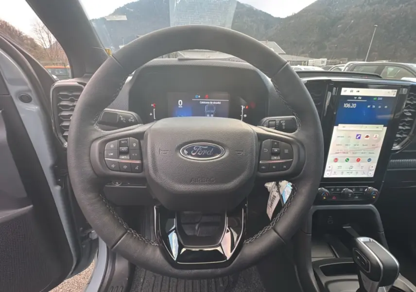 Vue intérieure centrée sur le volant cuir multifonctions et l’écran tactile vertical du Ford Ranger gris commandeur.