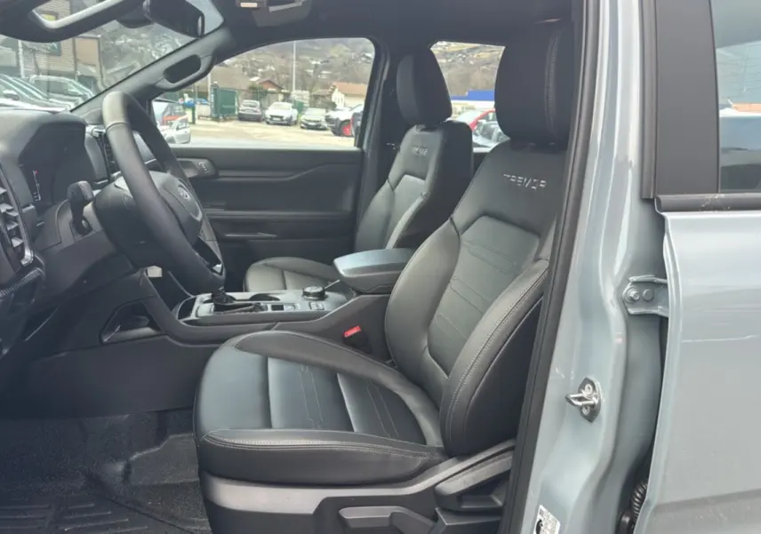 Vue intérieure côté gauche du Ford Ranger gris commandeur 2026, sièges en cuir noirs avec logo Tremor brodé.