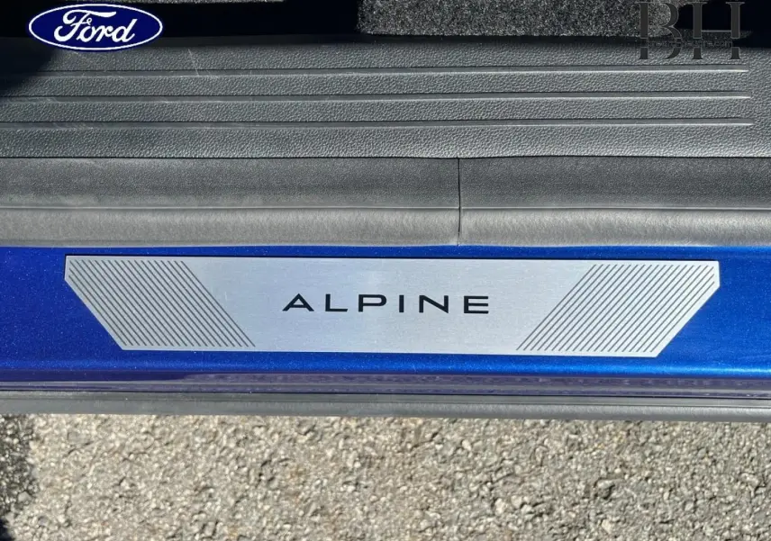 Gros plan sur la plaque de seuil de porte Alpine sur un Renault Austral Bleu Iron, vue côté gauche.