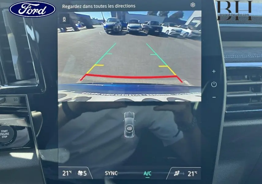 Écran tactile intérieur montrant la caméra de recul d'un Renault Austral Bleu Iron en stationnement.