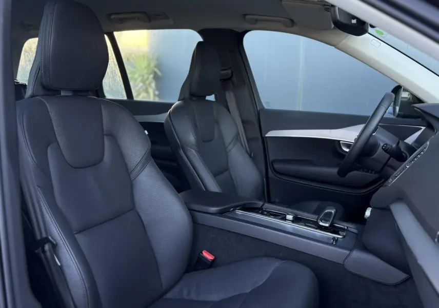 Intérieur du Volvo XC90 T8 2024 vu côté droit, sièges cuir noir et console centrale moderne avec accoudoir.