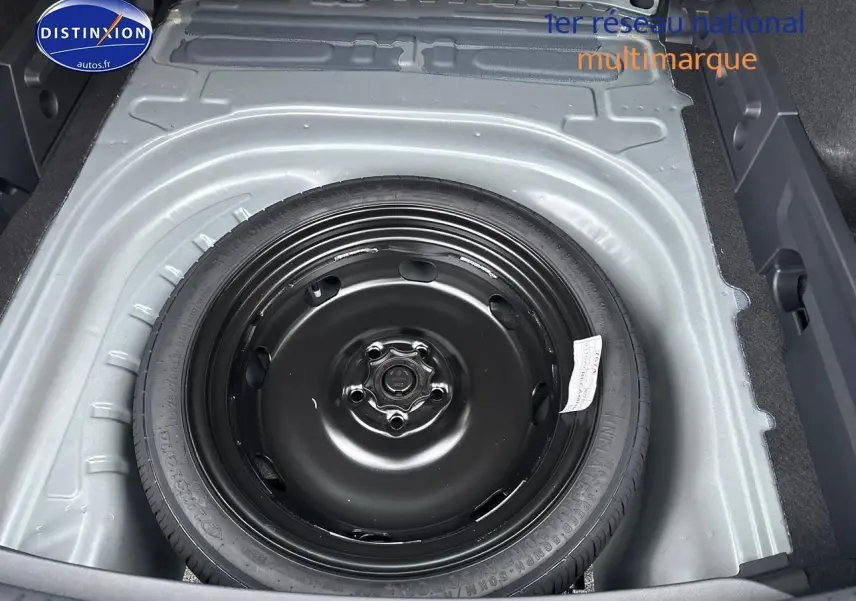 Vue plongeante sur la roue de secours noire dans le coffre gris magnétique d'une CUPRA LEON ST 2025.