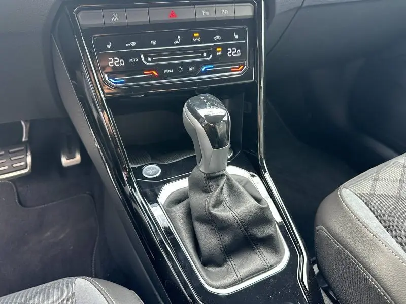 Le levier de vitesse automatique et la console centrale du Volkswagen T-ROC gris 1.5 TSI R-Line Edition 2025