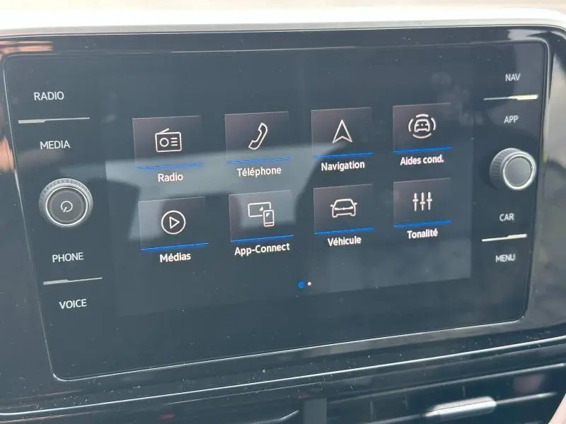 Écran tactile central du Volkswagen T-Roc 2025 gris, affichant le menu multimédia et aides à la conduite.