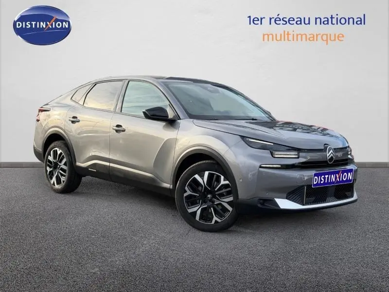 Citroën C4 X 2025 gris Mercury vue 3/4 avant droit, avec signature lumineuse distinctive et jantes noires bicolores.