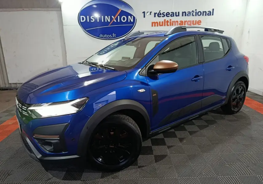 Vue 3/4 avant droite d'une Dacia Sandero Extreme+ TCe 110 bleu avec rétroviseurs bronze et jantes noires.