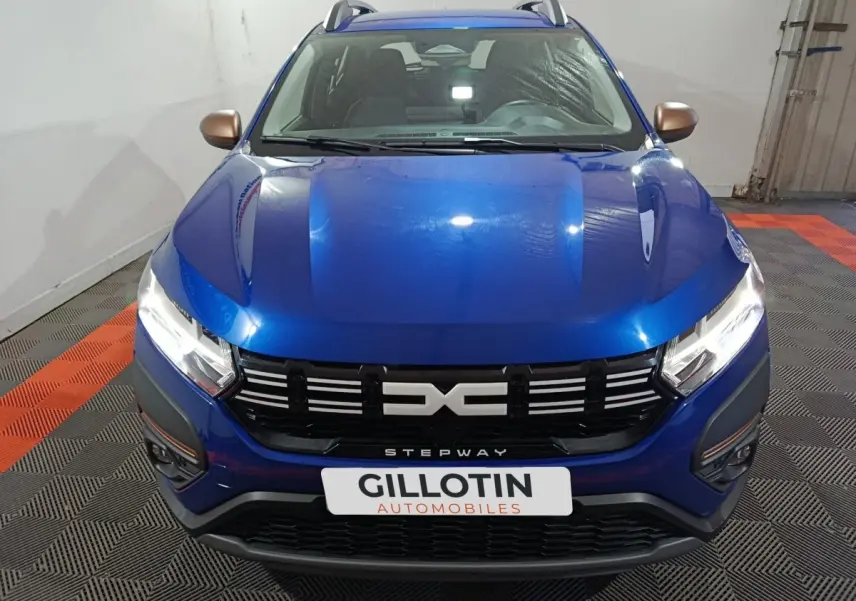 Vue avant d'une Dacia Sandero Extreme+ TCe 110 2024 bleu avec calandre noire et rétroviseurs cuivrés.