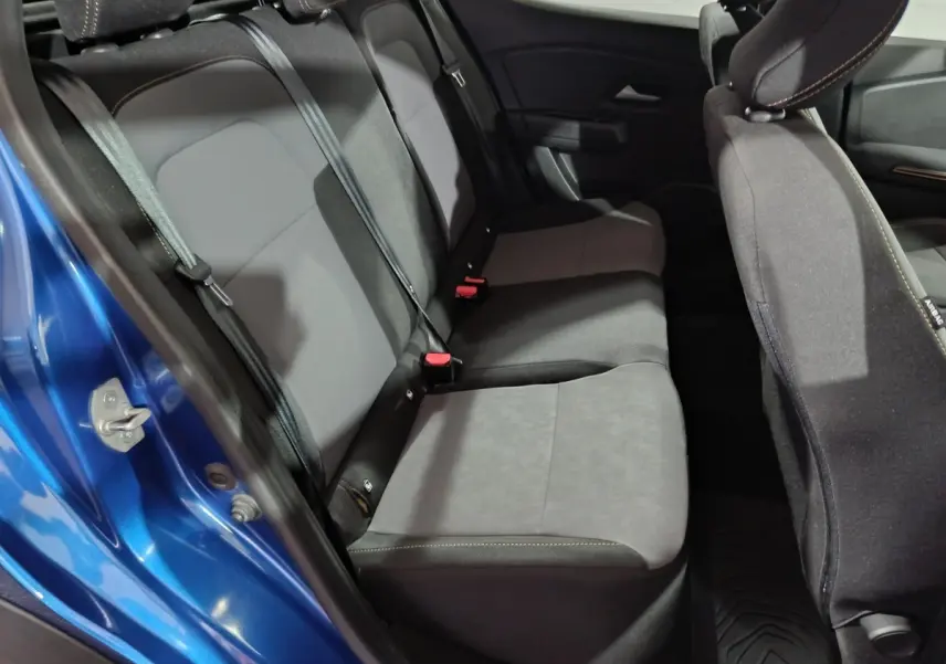 Vue côté gauche sur la banquette arrière grise et noire du Dacia Sandero Extreme+ TCe 110 bleu 2024 avec ceintures visibles.