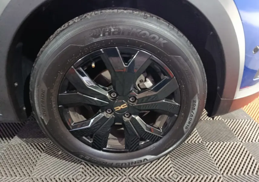 Gros plan sur la roue avant droite noire brillante d’une Dacia Sandero Extreme+ bleu 2024 avec pneu Hankook.