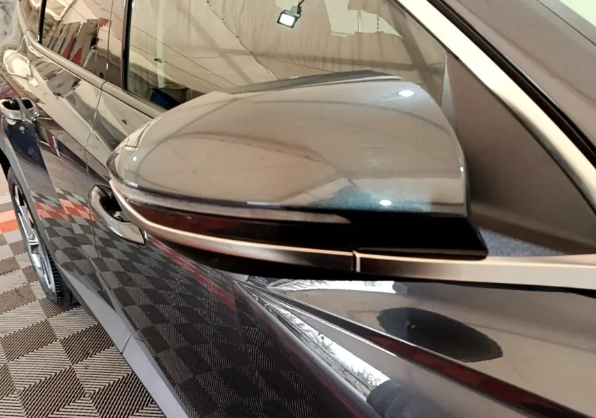 Gros plan sur le rétroviseur côté gauche gris foncé du Hyundai Tucson 2022 avec clignotant intégré.