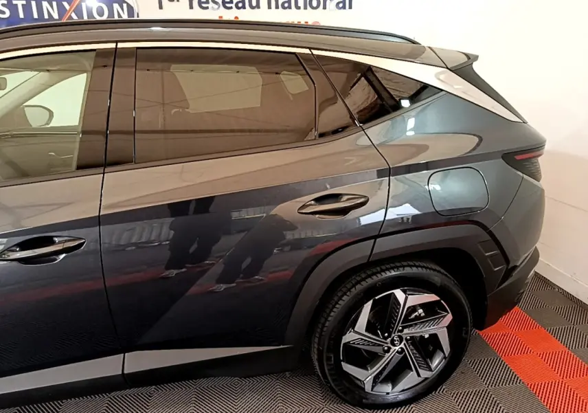 Vue côté droit arrière du Hyundai Tucson gris foncé 2022, mettant en valeur la porte arrière et la roue au design moderne.