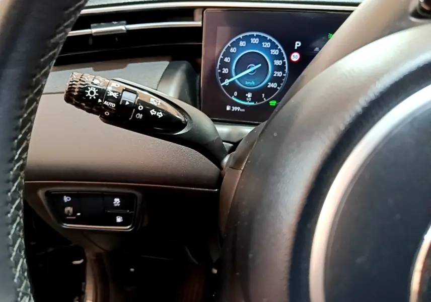 Vue rapprochée du tableau de bord du Hyundai Tucson 2022, affichage digital du compteur et commande des phares.