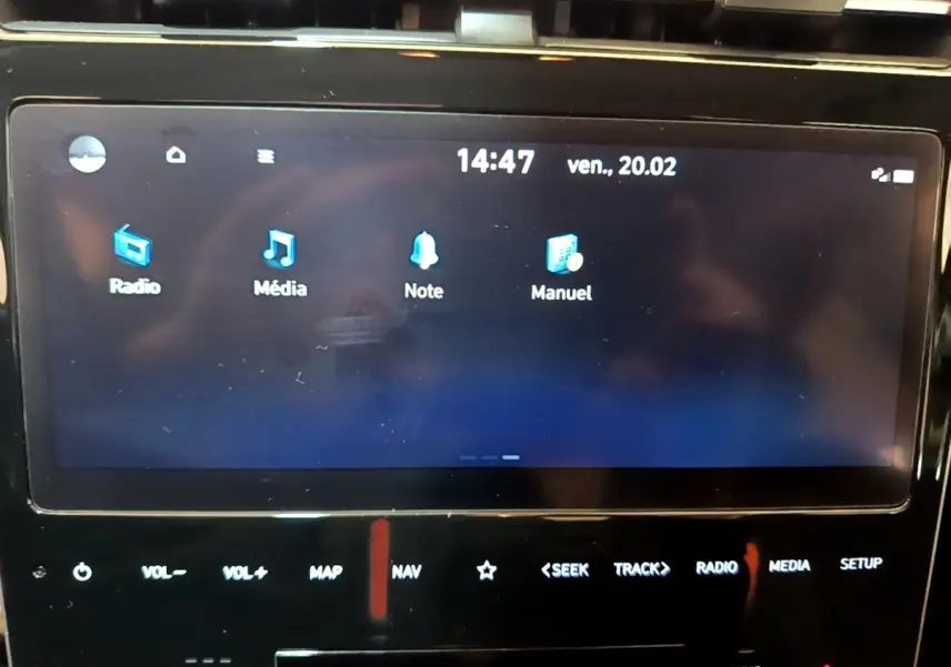 Écran tactile central affichant menu radio, média, note et manuel dans Hyundai Tucson gris foncé, vue intérieure frontale.