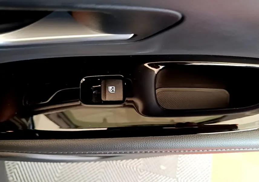 Gros plan sur la commande de verrouillage des vitres côté conducteur du Hyundai Tucson gris foncé, finition intérieure noire brillante.