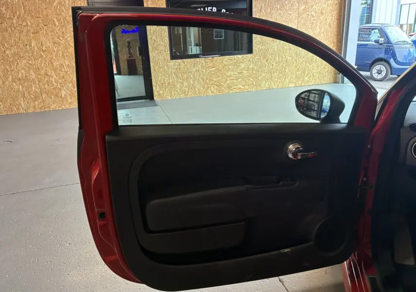 Vue intérieure de la porte avant gauche rouge et gris de l'Abarth 500 Competizione 2016 avec poignée chromée.