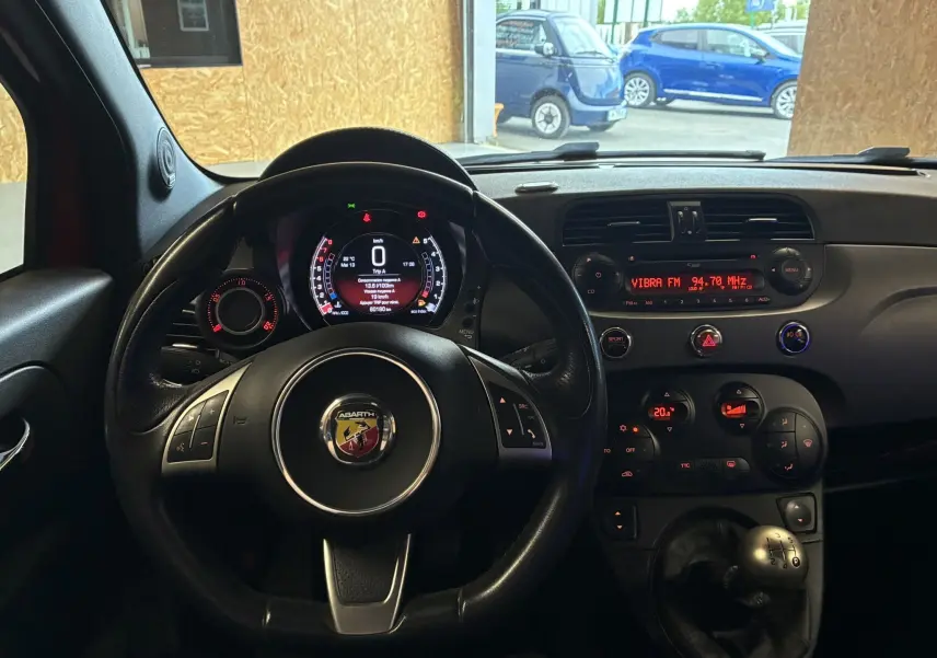 Vue intérieure frontale de l'Abarth 500 Competizione 2016, volant cuir noir avec logo Abarth et tableau de bord numérique.