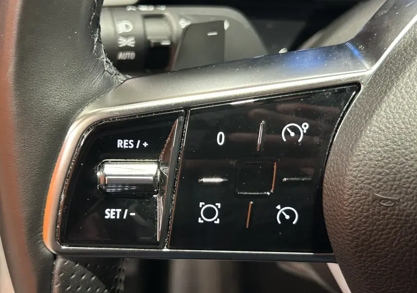Gros plan sur les commandes de régulateur de vitesse au volant cuir noir du Renault Austral 2024.