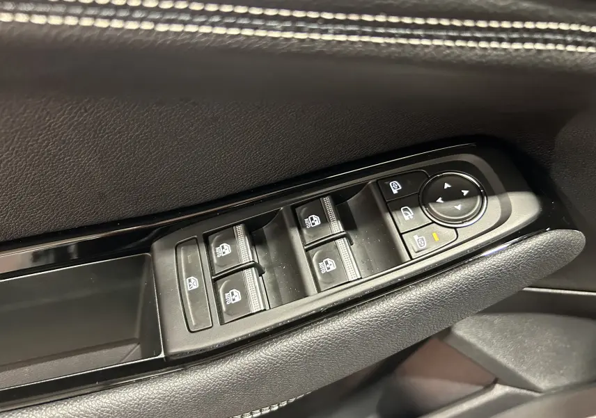 Gros plan sur les commandes de lève-vitres et rétroviseurs côté conducteur d’un Renault Austral 2024 noir.
