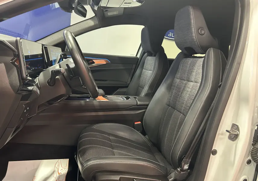 Vue intérieure côté conducteur du Renault Austral blanc nacré 2024, sièges en cuir noir avec surpiqûres blanches et tableau de bord moderne.