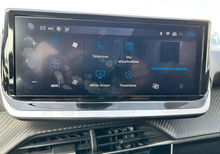 Écran tactile central de la Peugeot 208 Hybrid 110 gris, affichant les options de climatisation et connectivité.