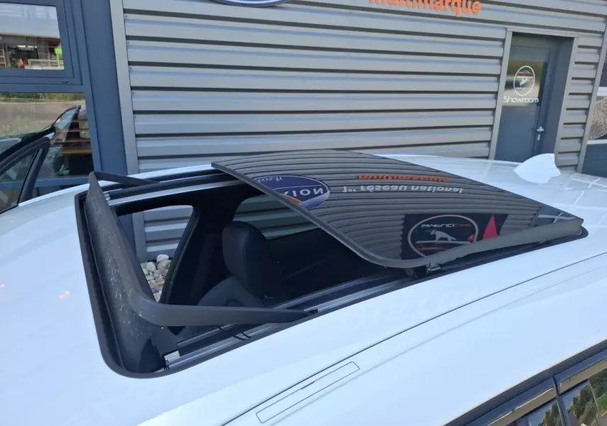 Toit ouvrant panoramique ouvert sur une BMW Série 1 118D M Sport blanc vue de dessus côté gauche.