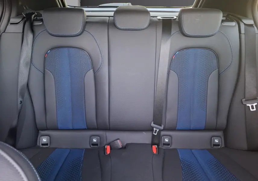 Vue intérieure des sièges arrière baquets en cuir et tissu bleu et noir de la BMW Série 1 118D M Sport 2021.