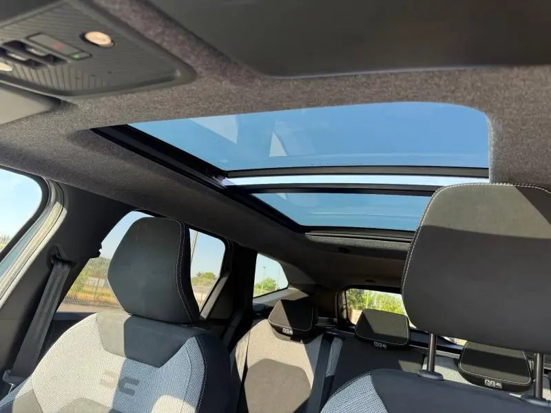 Vue intérieure du Dacia Bigster gris Schiste montrant les sièges avant et arrière avec toit panoramique en verre.