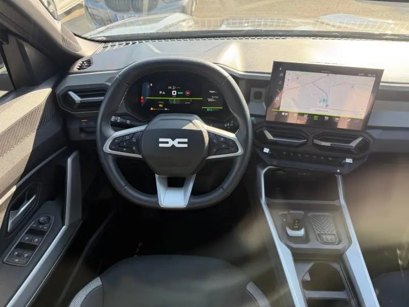 Vue intérieure du tableau de bord de la Dacia Bigster gris schiste, avec volant multifonction et écran tactile GPS.