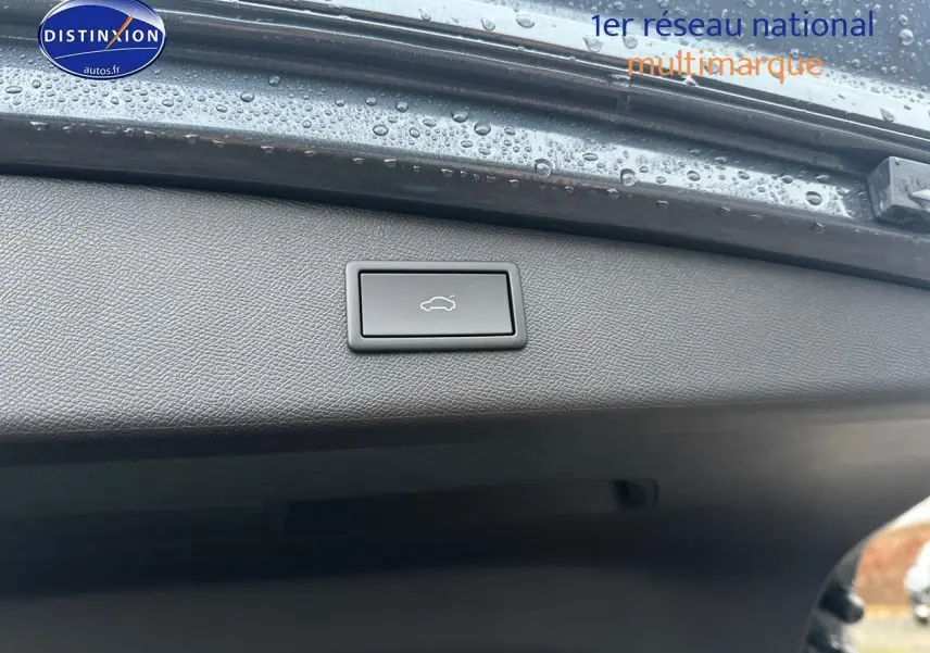 Bouton d'ouverture électrique du coffre sur la trappe arrière d'une CUPRA LEON ST gris magnétique, vue rapprochée intérieure.