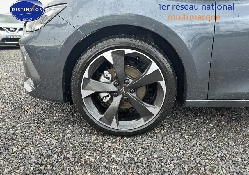 Gros plan sur la roue avant gauche d'une CUPRA LEON ST gris magnétique, avec jante alu au design sportif.