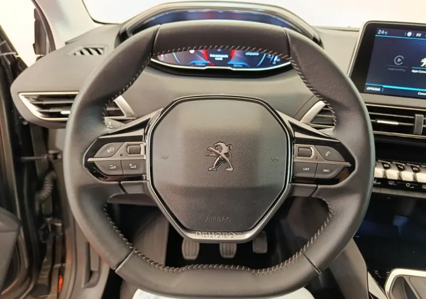 Vue rapprochée du volant cuir multifonctions du Peugeot 3008 gris foncé, avec tableau de bord digital et écran tactile visible.