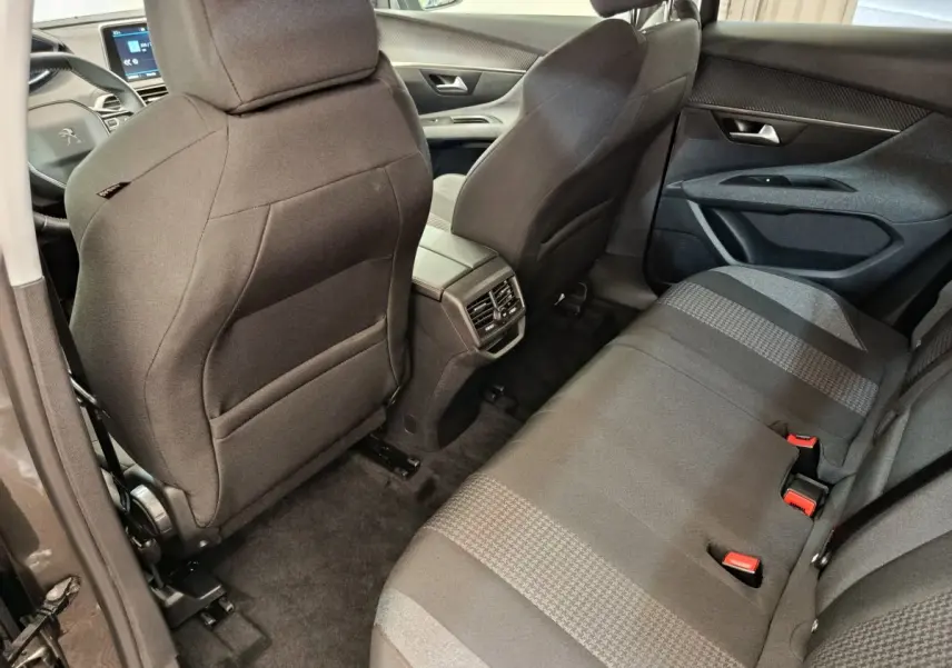 Vue arrière intérieure du Peugeot 3008 gris foncé, montrant les sièges arrière et la console centrale avec aérateurs.