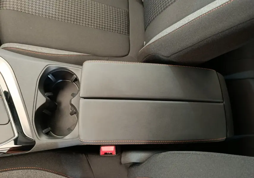 Vue rapprochée de l'accoudoir central noir avec surpiqûres orange et porte-gobelets du Peugeot 3008 gris foncé 2020.