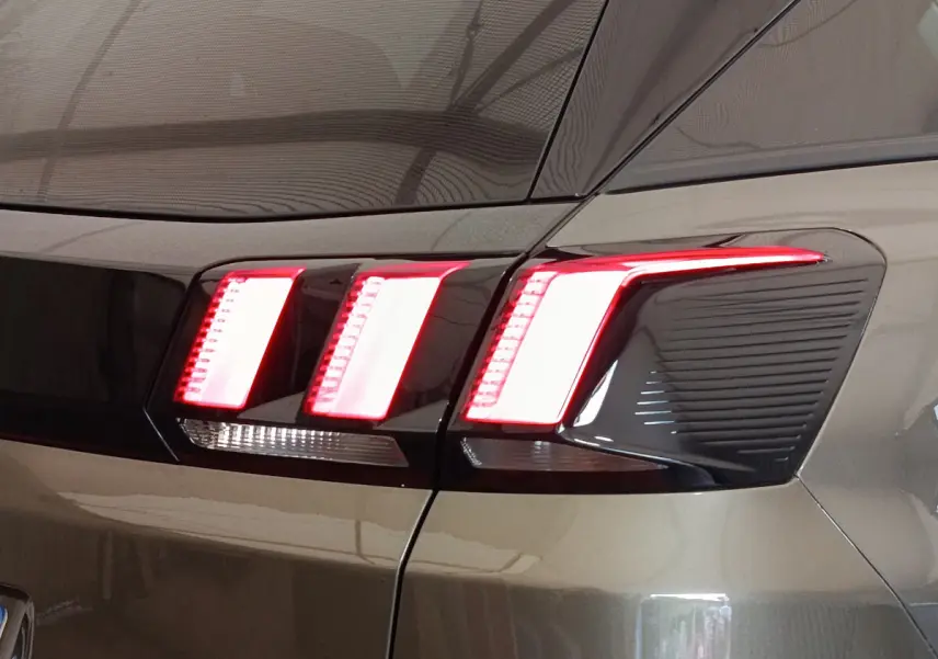 Gros plan sur le feu arrière droit rouge et blanc du Peugeot 3008 gris foncé, version Puretech 130 S&S Active Business.