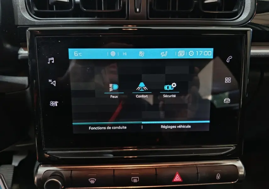 Écran tactile central allumé de la Citroën C3 gris foncé, affichant les réglages Feux, Confort et Sécurité.