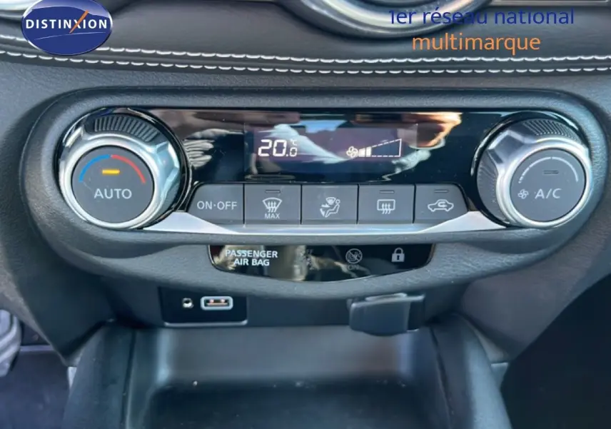 Détail de la console centrale du Nissan Juke 2024 gris, montrant les commandes de climatisation automatique et écran digital.