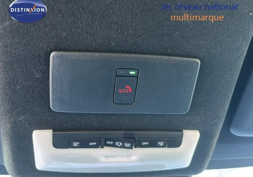 Vue intérieure du plafond du Nissan Juke Hybrid 2024 gris, montrant les commandes d’éclairage et le bouton SOS.