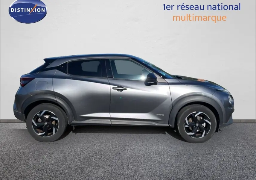 Profil droit du Nissan Juke Hybrid 143ch Business+ 2024 en gris squale metal avec jantes noires bicolores.