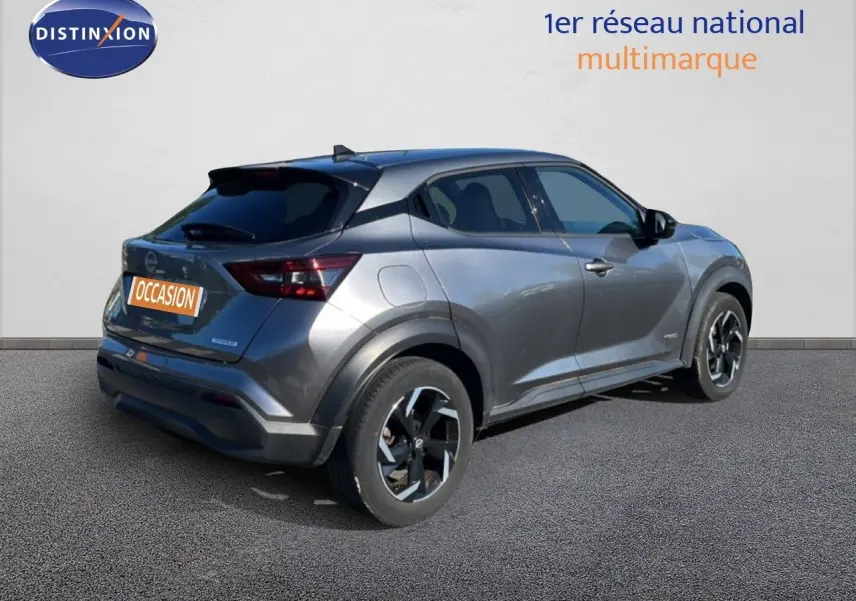 Nissan Juke Hybrid gris squale métal vu en 3/4 arrière droit, soulignant ses lignes modernes et ses jantes bi-ton.