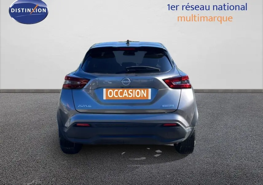 Vue arrière d’un Nissan Juke Hybrid gris squale métal avec plaque « OCCASION » sur fond neutre.