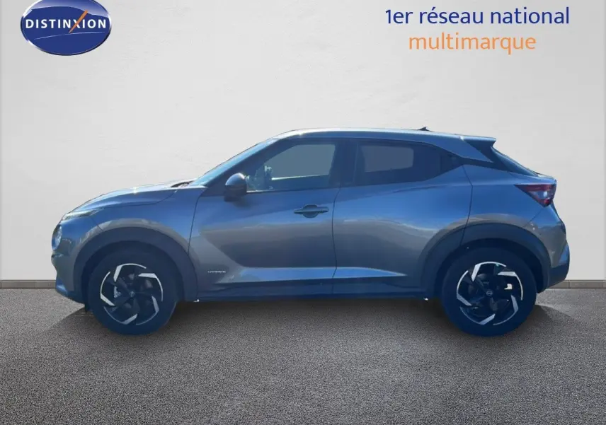 Profil droit du Nissan Juke Hybrid gris squale metal 2024 avec jantes noires et détails modernes.