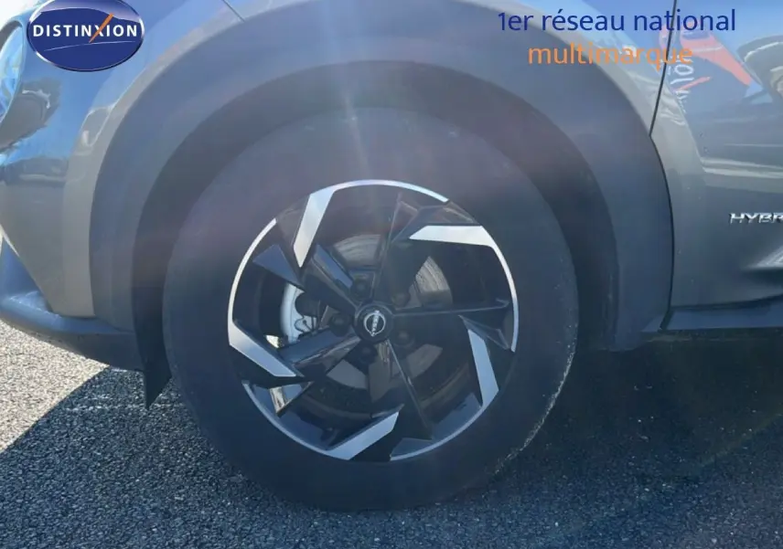 Gros plan sur la roue avant gauche du Nissan Juke gris squale métal, avec jante noire et argentée au design moderne.