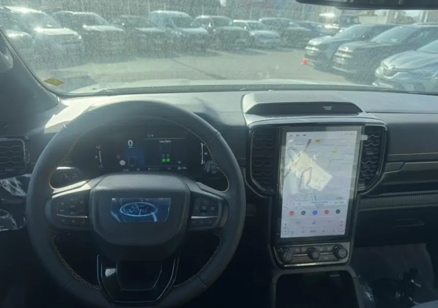 Vue intérieure du tableau de bord du Ford Ranger Wildtrak 2025 avec volant multifonctions et écran tactile vertical.