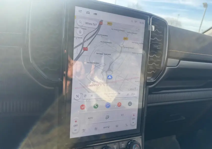 Vue rapprochée de l’écran tactile central du Ford Ranger gris 2025, affichant la navigation GPS et la console de climatisation.