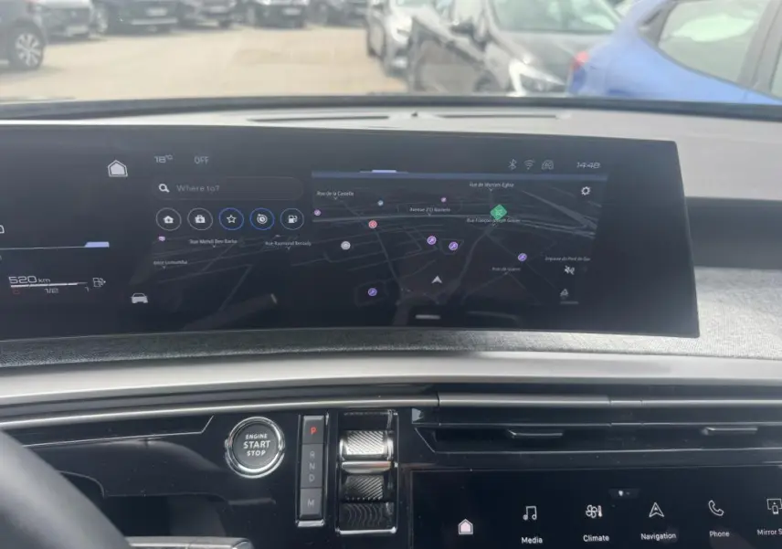 Vue intérieure du tableau de bord du Peugeot 5008 Hybrid 2025 avec écran tactile de navigation et bouton start/stop.